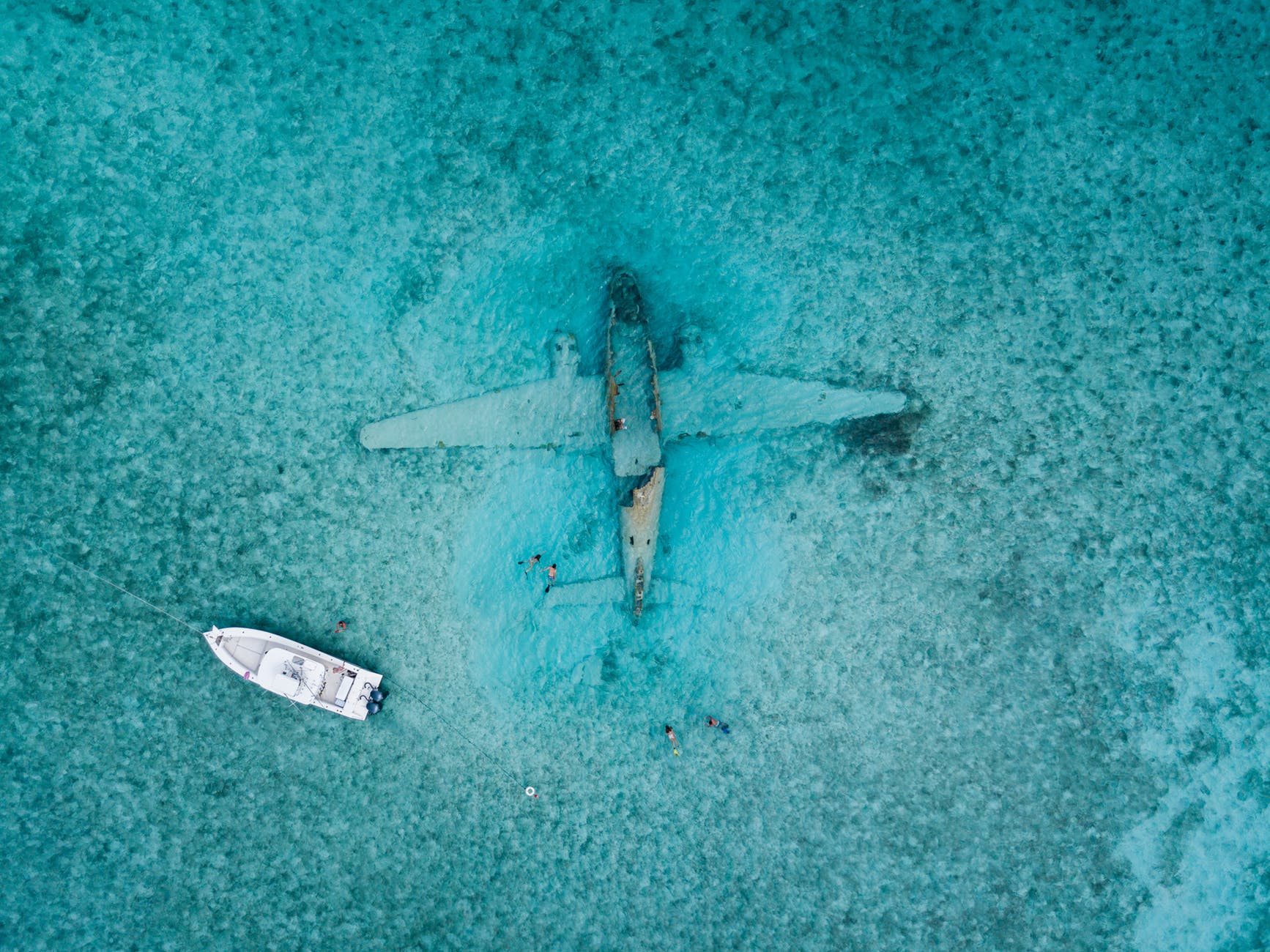 top view photo of boat near airplane