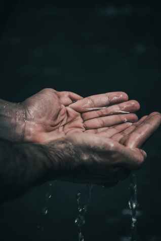 person holding water in cupped hands
